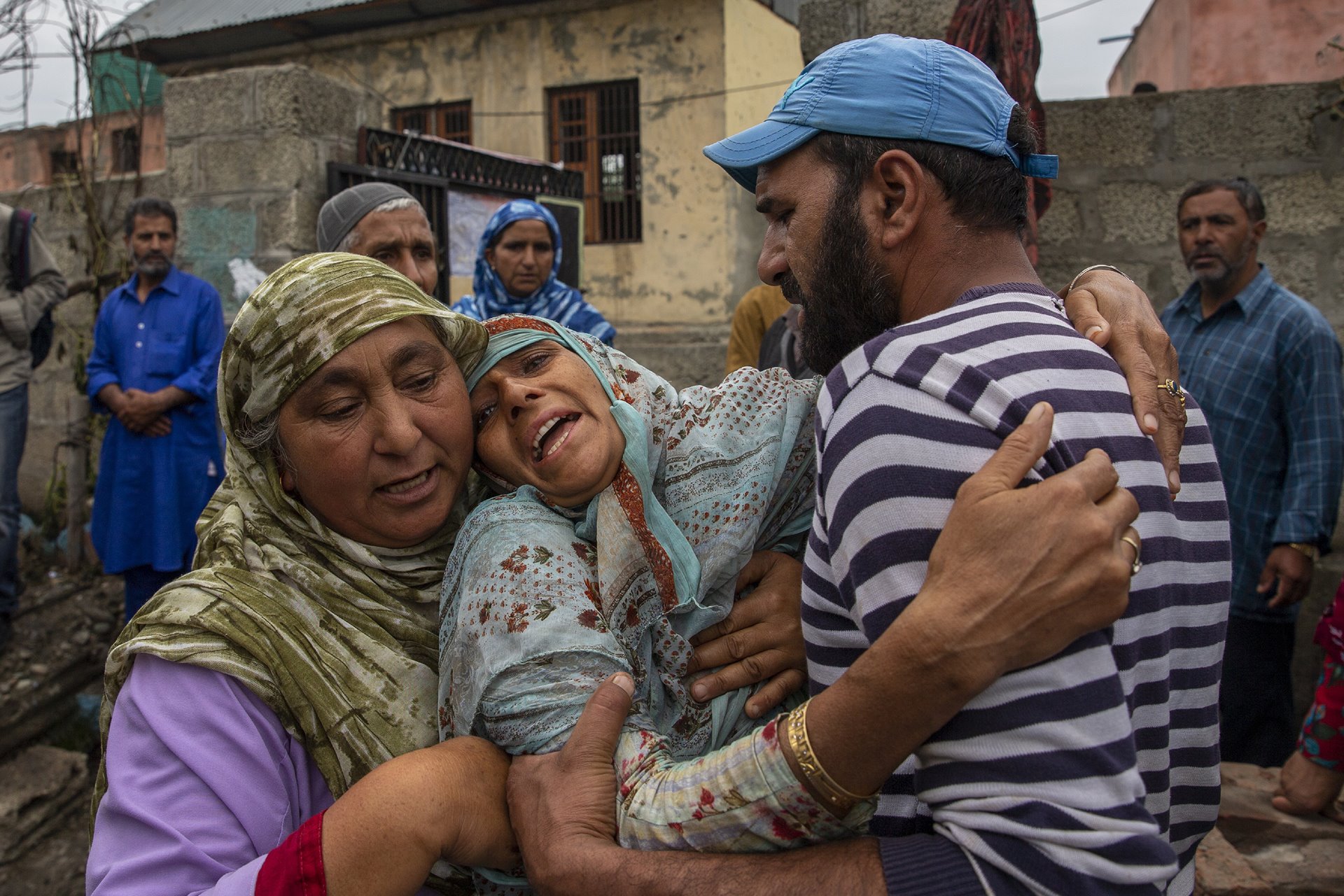 A woman cries beside her home, which was damaged in a gunfight after suspected militants took refuge there, in Pulwama, south of Srinagar, in Indian-administered Kashmir. Officials said that three suspected militants were killed in the fight. Two other homes were damaged.