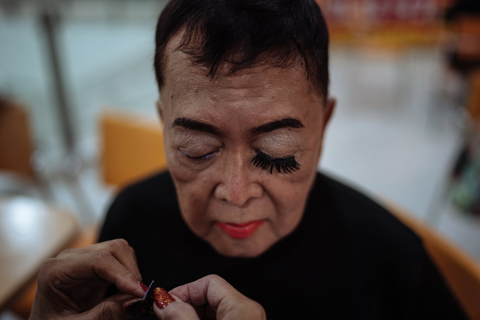 Ramon Busa, or &lsquo;Lola Mon&rsquo; (72), president of the Golden Gays, has her eyelashes applied before a performance in Manila, the Philippines.