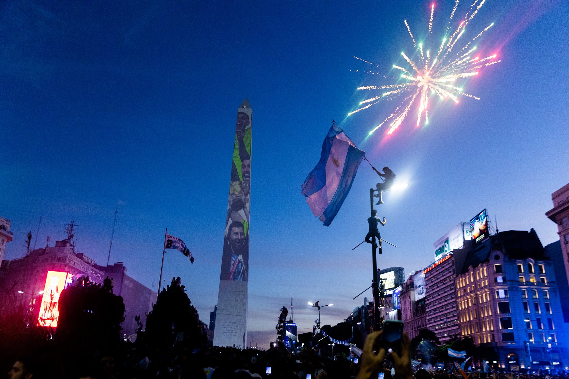 Fireworks explode overhead as fans raise the flag of Argentina next to the Obelisco de Buenos Aires, a national historical monument located in the Argentinian capital&rsquo;s main square.&nbsp;