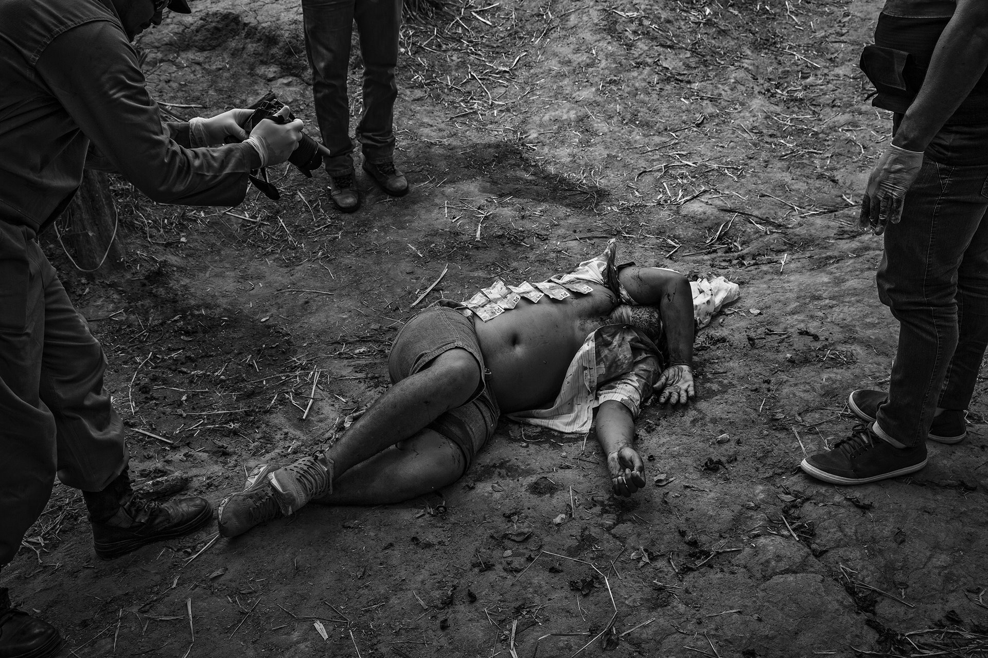 <p>Police officers examine the body of a man killed in rural Altamira, near the Belo Monte Dam, Pará, Brazil. They have laid out banknotes found on the dead man, which they say indicates this was not a robbery but an extra-judicial killing. The 2017 Violence Atlas, published annually by Brazil&rsquo;s Institute of Applied Economic Research (IPEA), ranked Altamira as Brazil&rsquo;s most violent city.</p>

