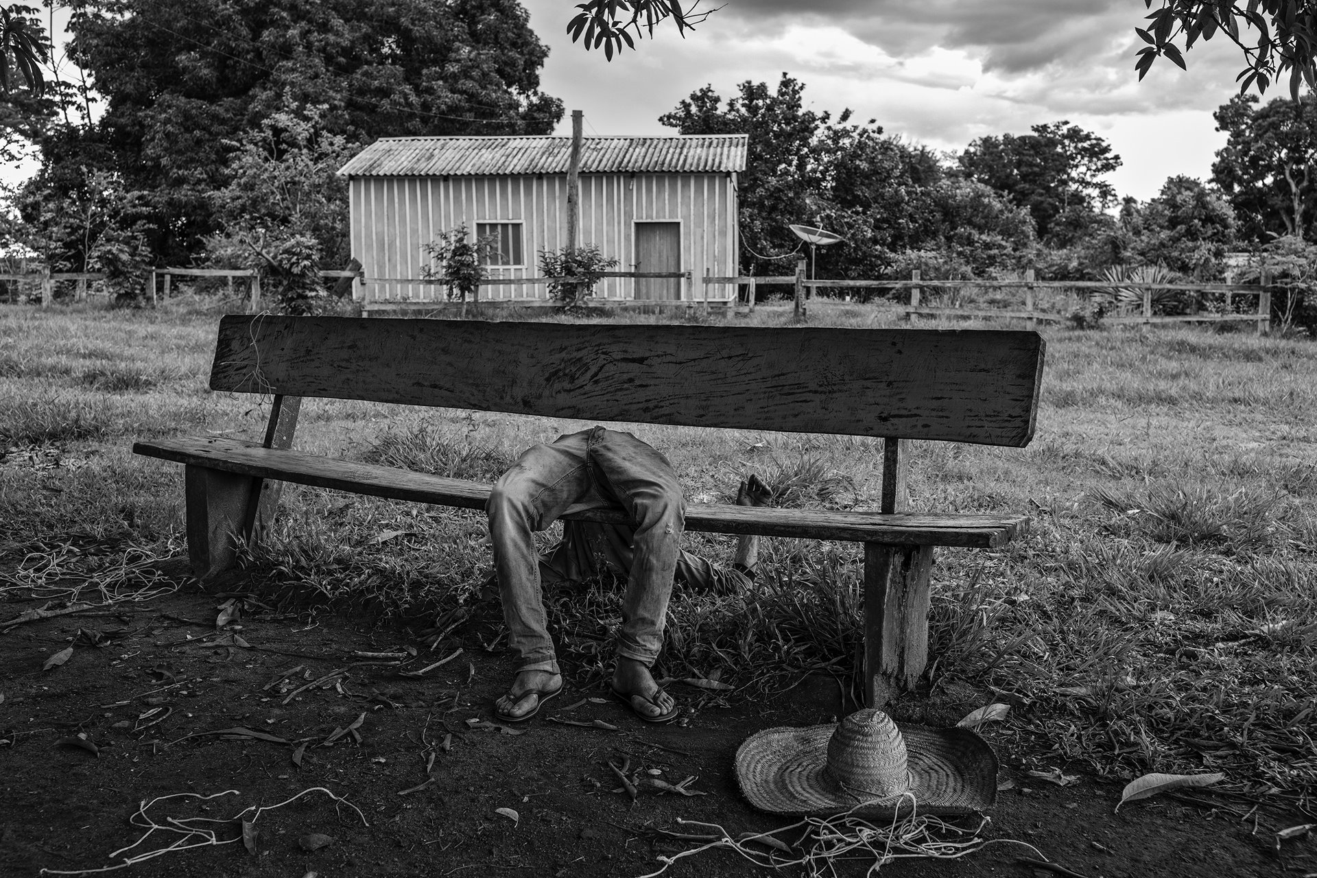 A member of the Quilombola community &ndash;&ensp;an Afro-Brazilian community consisting of Black Brazilians, some of whom are descendants of enslaved peoples from the African continent &ndash; lies passed out drunk on a bench, in Pedras Negras, São Francisco do Guaporé, Rondônia, Brazil. The process of providing land deeds to communities started by former enslaved people was already slow before Jair Bolsonaro&#39;s election. It has now stalled completely, as a result of the president&rsquo;s resolve not to demarcate further land for such communities in the Amazon.
