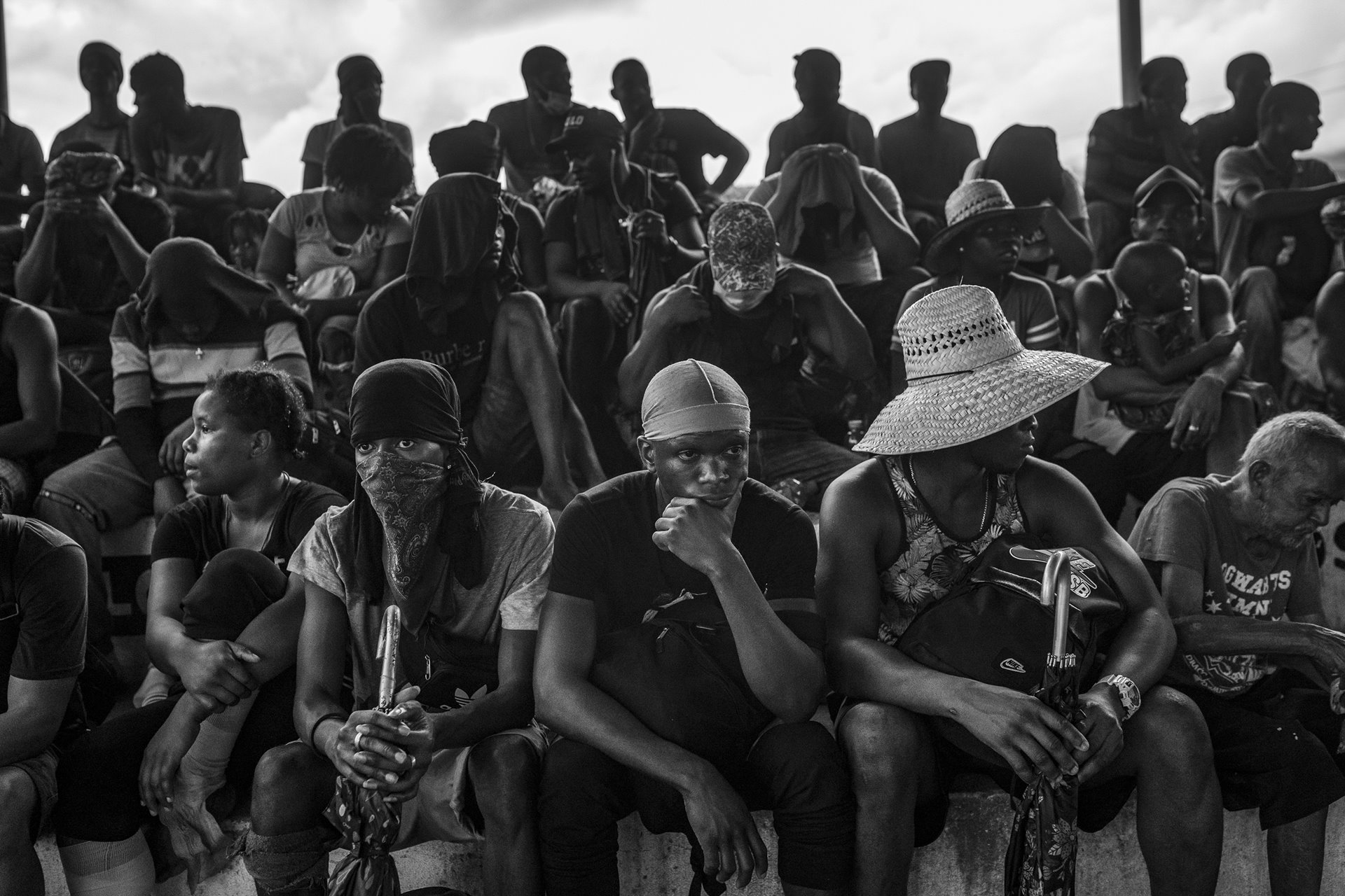 Haitian migrants and asylum seekers wait in line to receive food from a local church after walking 40 kilometers as part of a migrant caravan leaving from Tapachula, Mexico. Tapachula, near the border with Guatemala, serves as a compulsory stop for migrants and asylum seekers because one of the offices of the Mexican Commission for Aid to Refugees (COMAR) is located in the city. Local NGOs accuse COMAR of corruption: selling humanitarian visas to those who can afford them and deliberately delaying visas to others to curb the influx of migrants toward the US-Mexico border.