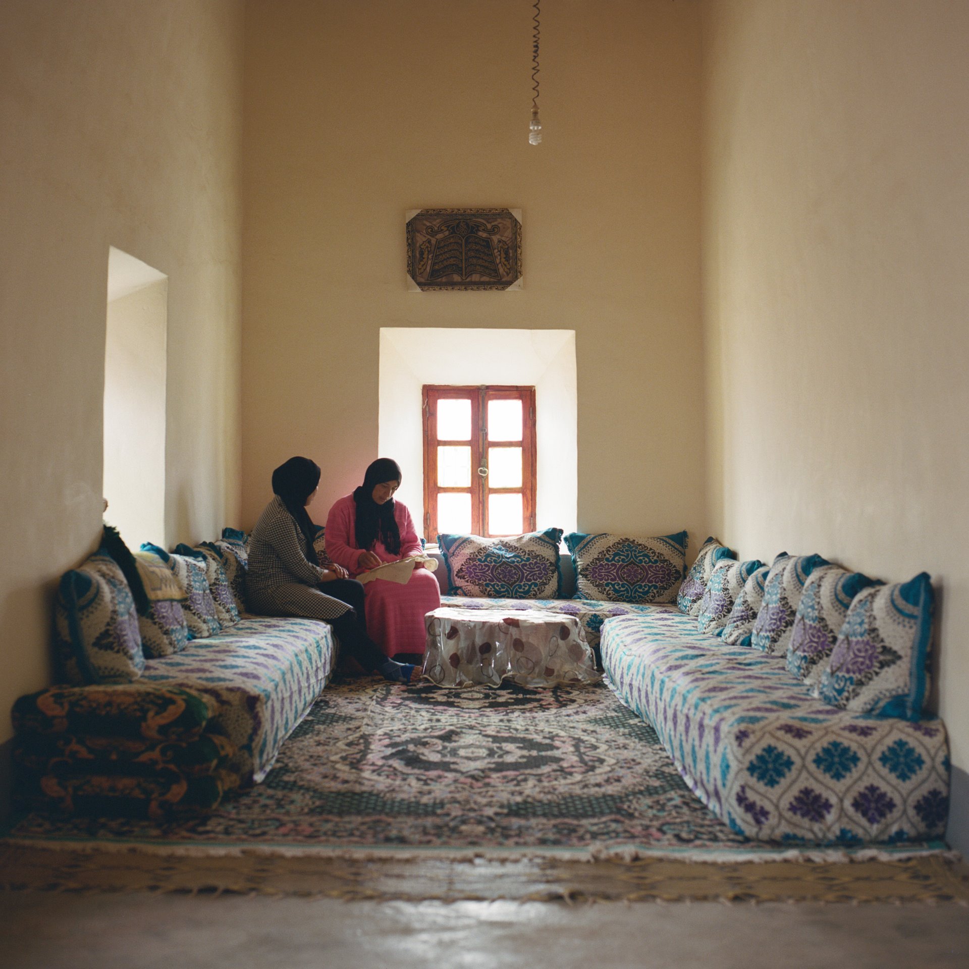 Zakia Erroukna (39) and Hayat El Yamani (34) discuss embroidery techniques in Zakia&rsquo;s living-room, at Skoura Oasis, in central Morocco. Some 20,000 people live among nearly 140,000 palm trees at the oasis. Most live from the produce they grow, and from date palms.