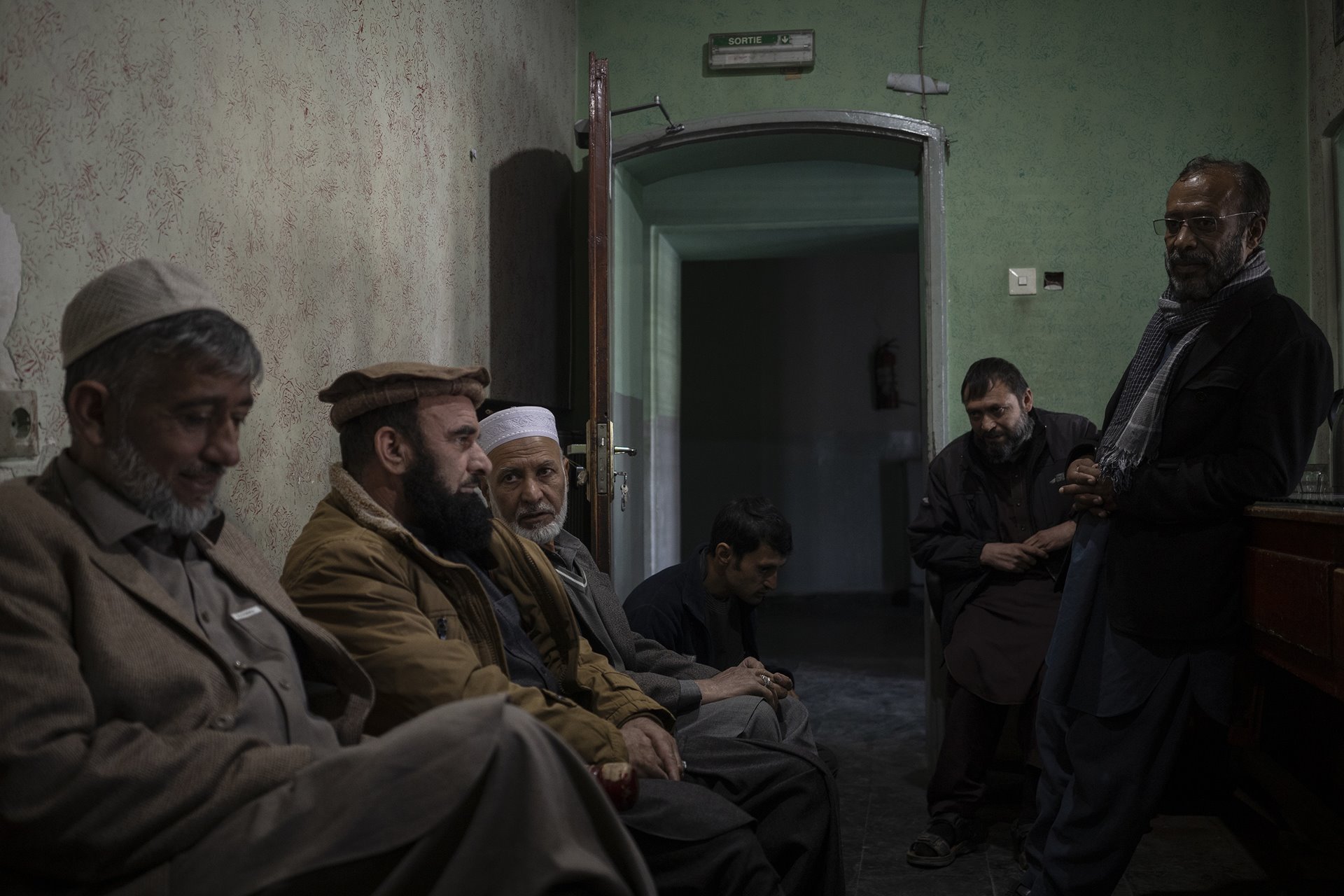Staff members sit inside the ticket office of the Ariana Cinema in Kabul, Afghanistan. Nearly three months after the Taliban closed the government-owned cinema, the staff still arrive for work in the hope that they will be paid.